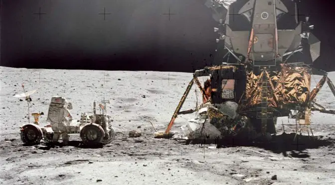 John W. Young, commander of the Apollo 16 lunar landing mission, works at the Lunar Roving Vehicle (LRV)