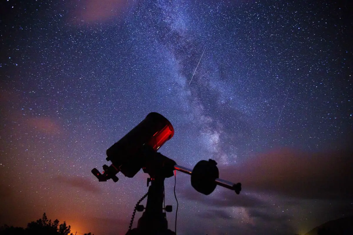 Telescope and starry night sky