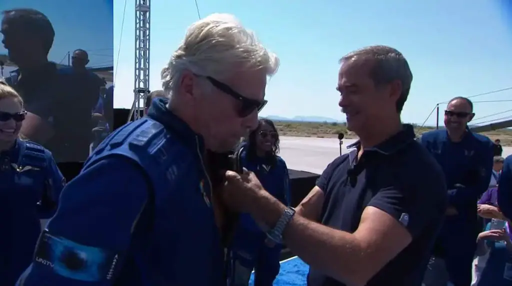 Hadfield decorates Richard Branson with Astronaut Badge