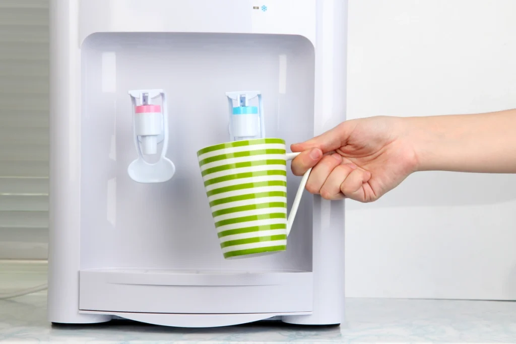 Woman filling cup at water cooler