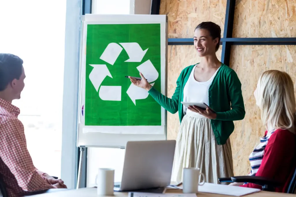 Colleagues discussing with recycling sign - corporate recycling