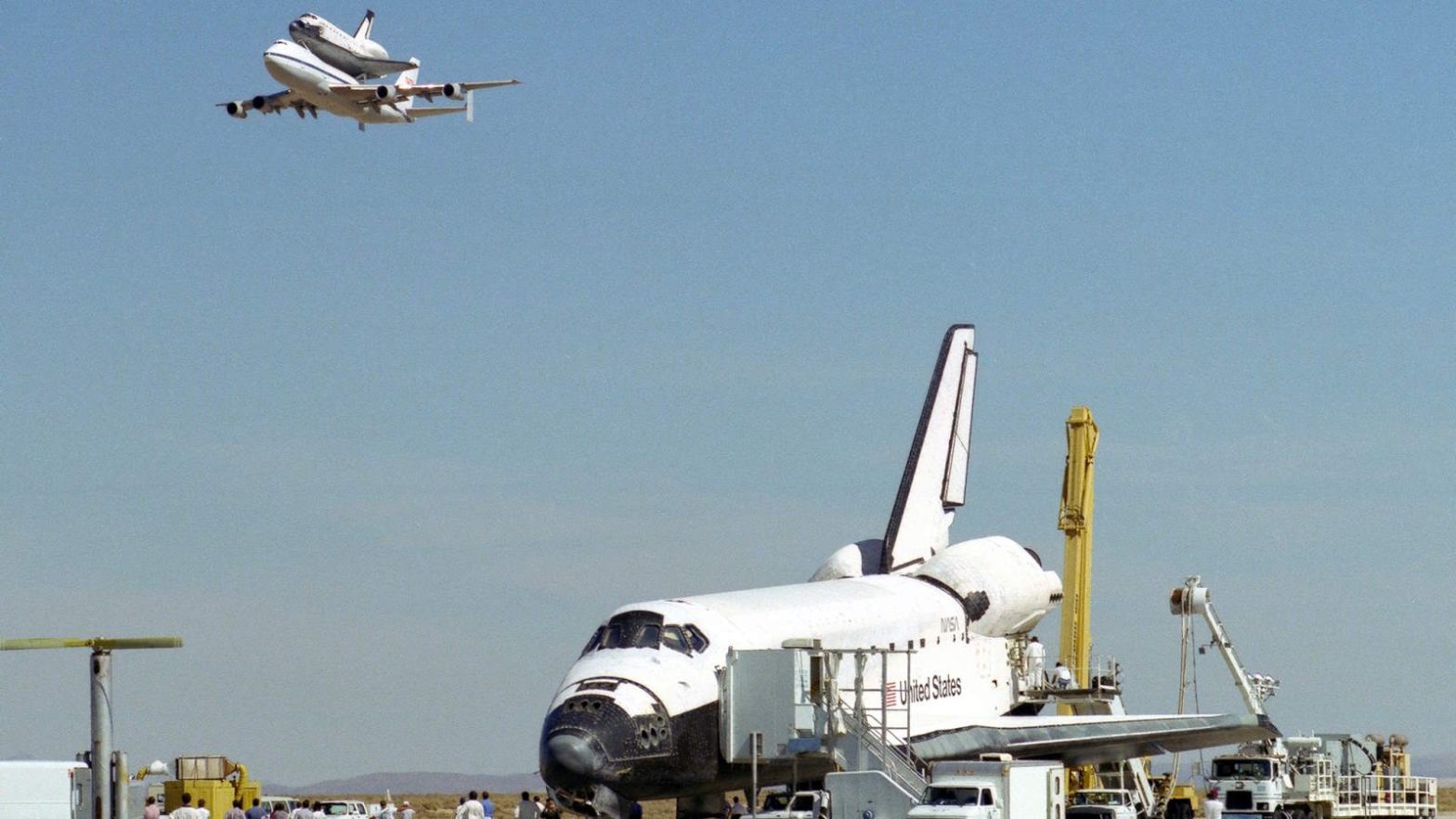 The space shuttle Endeavour receives a high-flying salute from its sister shuttle, Columbia, atop NASA's Shuttle Carrier Aircraft, shortly after the landing of Endeavour on October 11, 1994